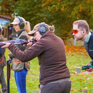 Flintencoach Felix Haase schaut einer Flintenschützin bei der praktischen Übung über die Schulter
